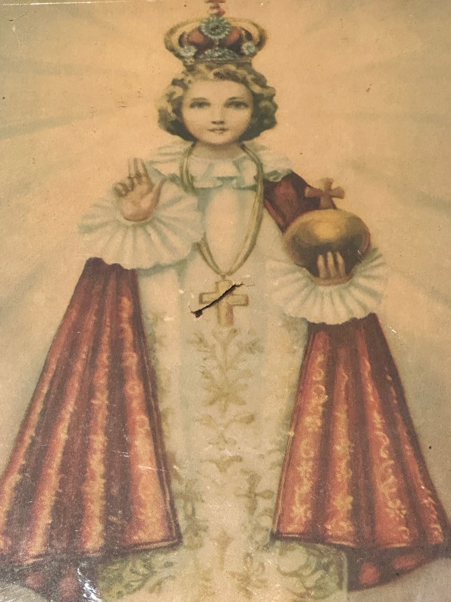 "Infant Jesus of Prague" print, full figure in white and red robes holding gold orb, aged paper with crease