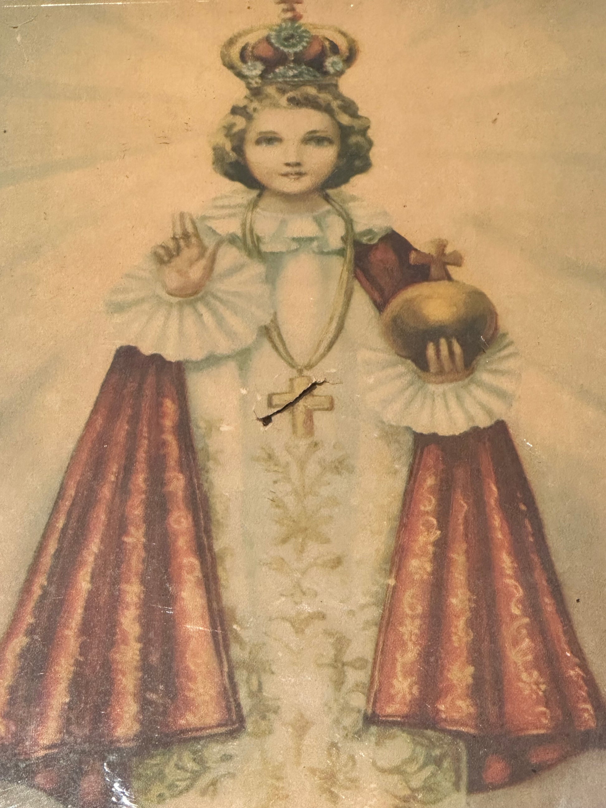 "Infant Jesus of Prague" print, full figure in white and red robes holding gold orb, aged paper with crease