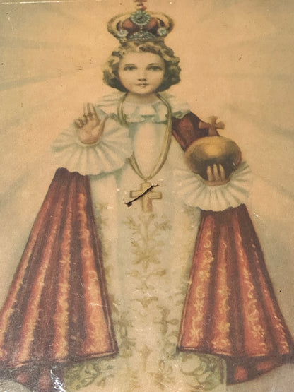 "Infant Jesus of Prague" print, full figure in white and red robes holding gold orb, aged paper with crease
