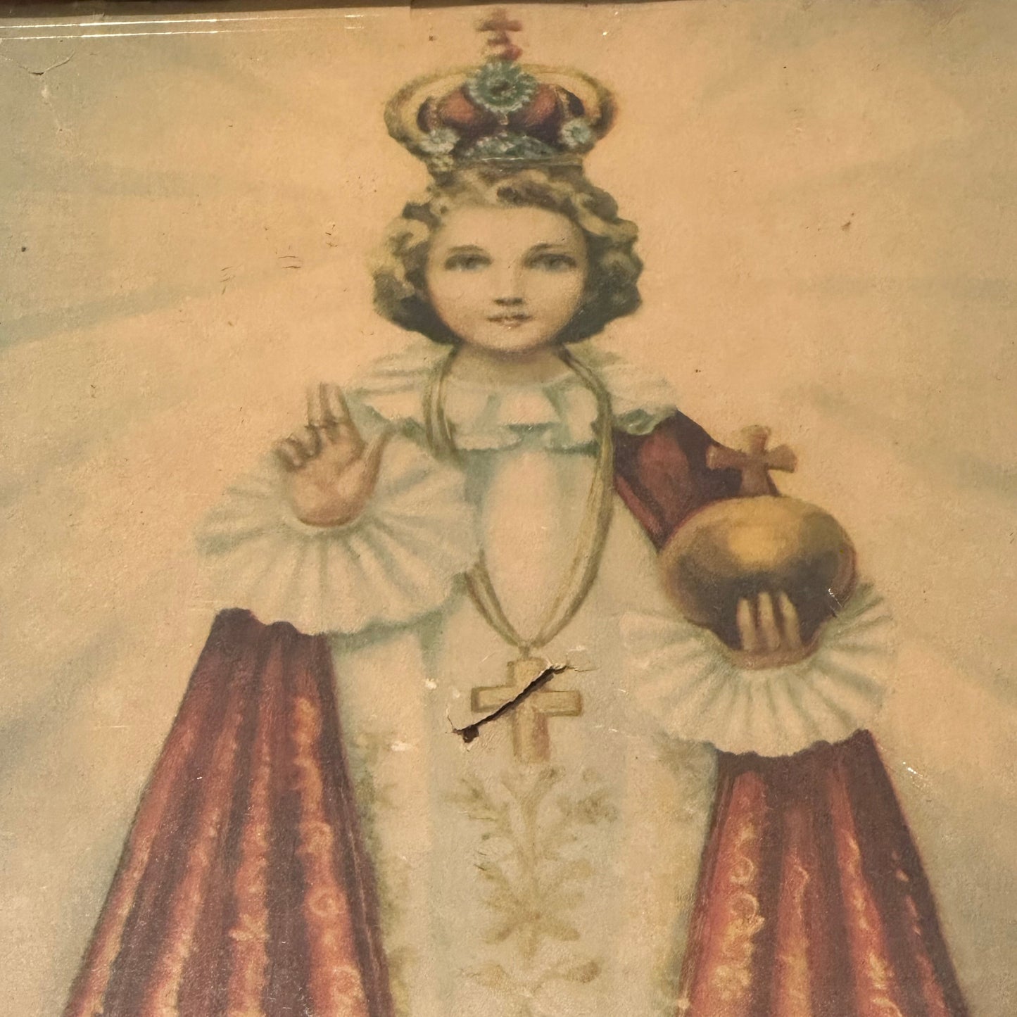 Close-up of "Infant Jesus of Prague" print: crowned child Jesus with raised hand of blessing, holding gold globe cruciger