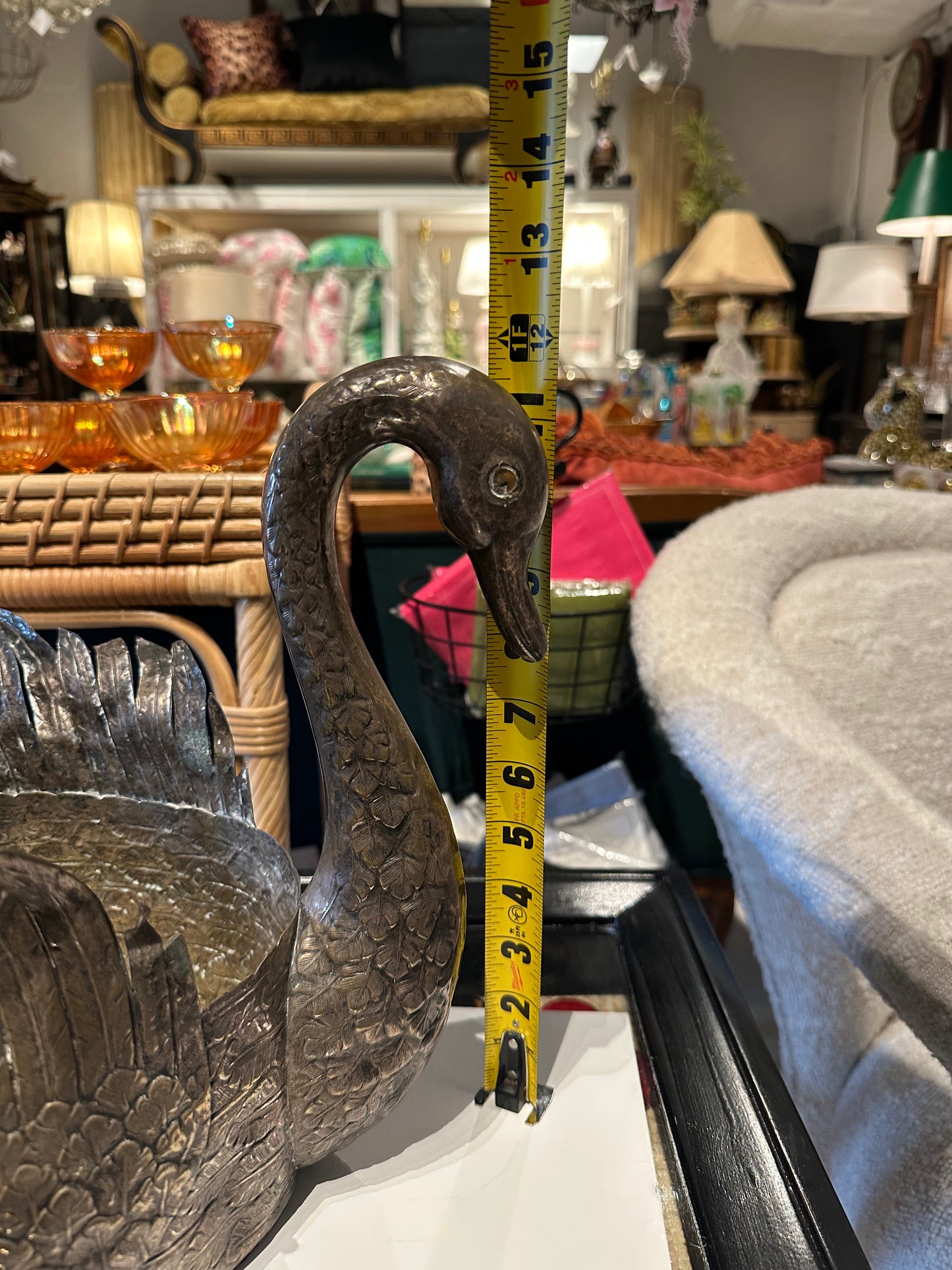 Swan jardiniere with tape measure showing neck height near 15 inches in a furnished room