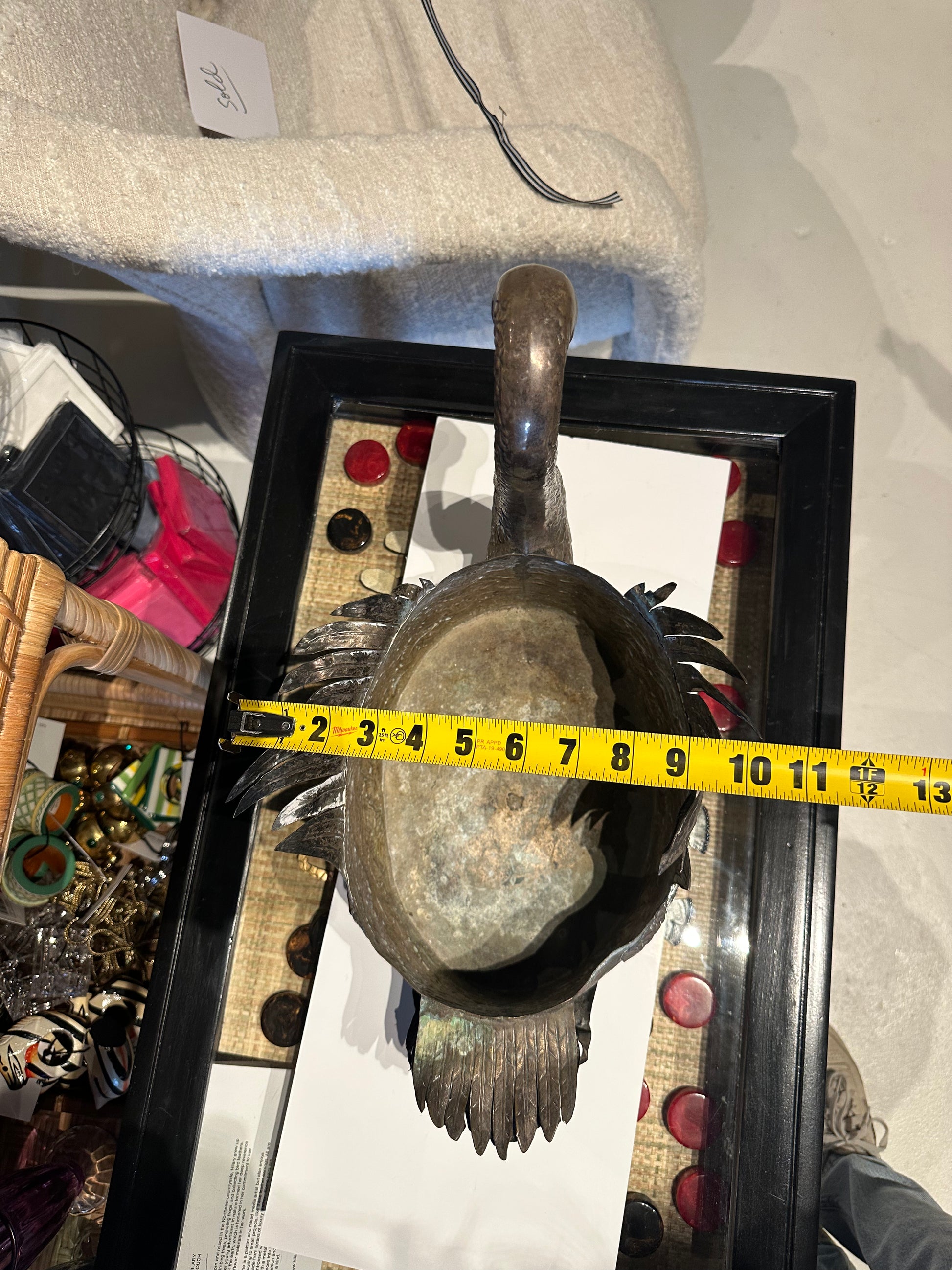 Top view of the swan jardiniere with a tape measure indicating roughly 13 inches in length