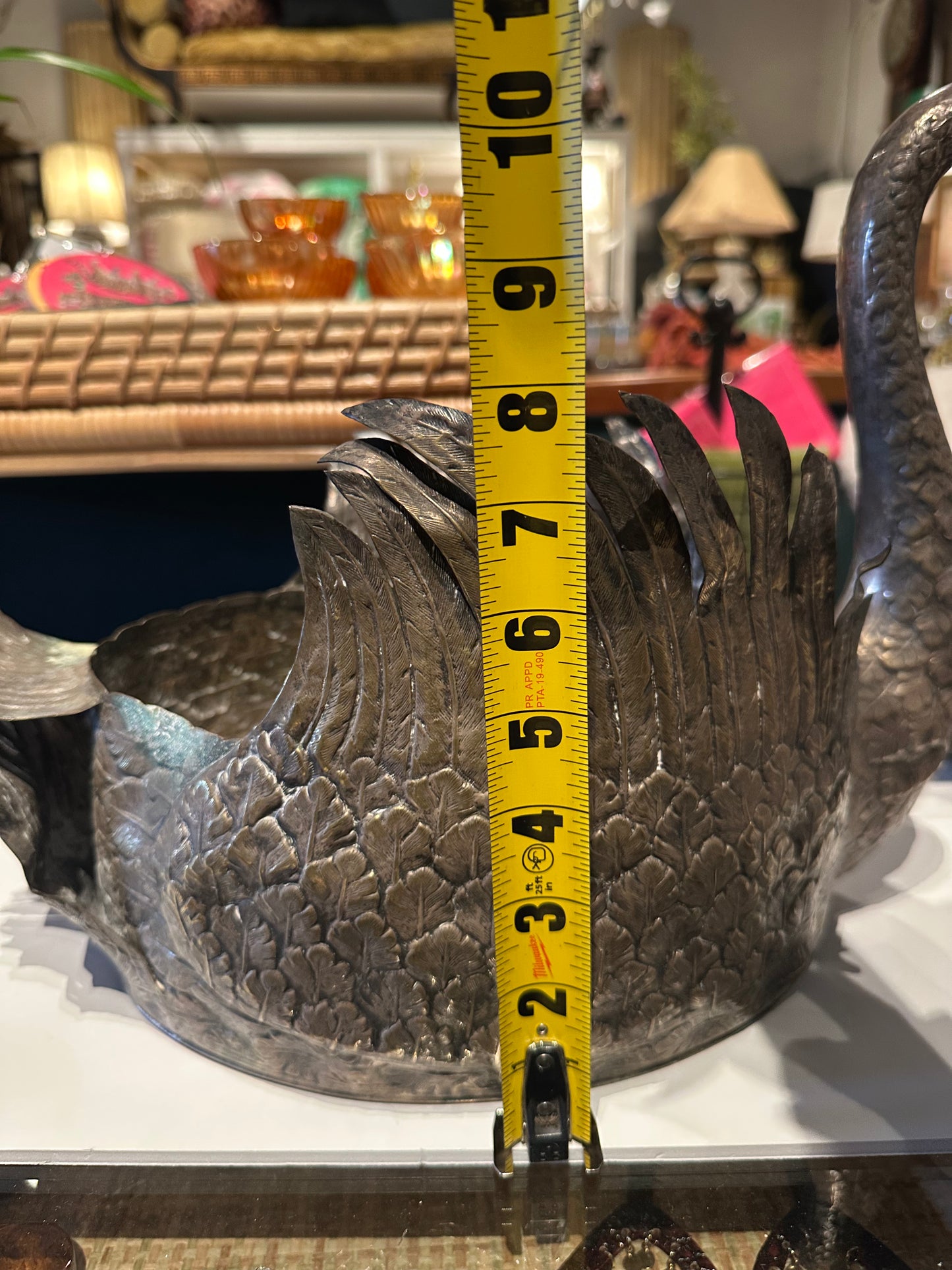 Silver-plated swan jardiniere beside a tape measure showing body height of about 7 inches