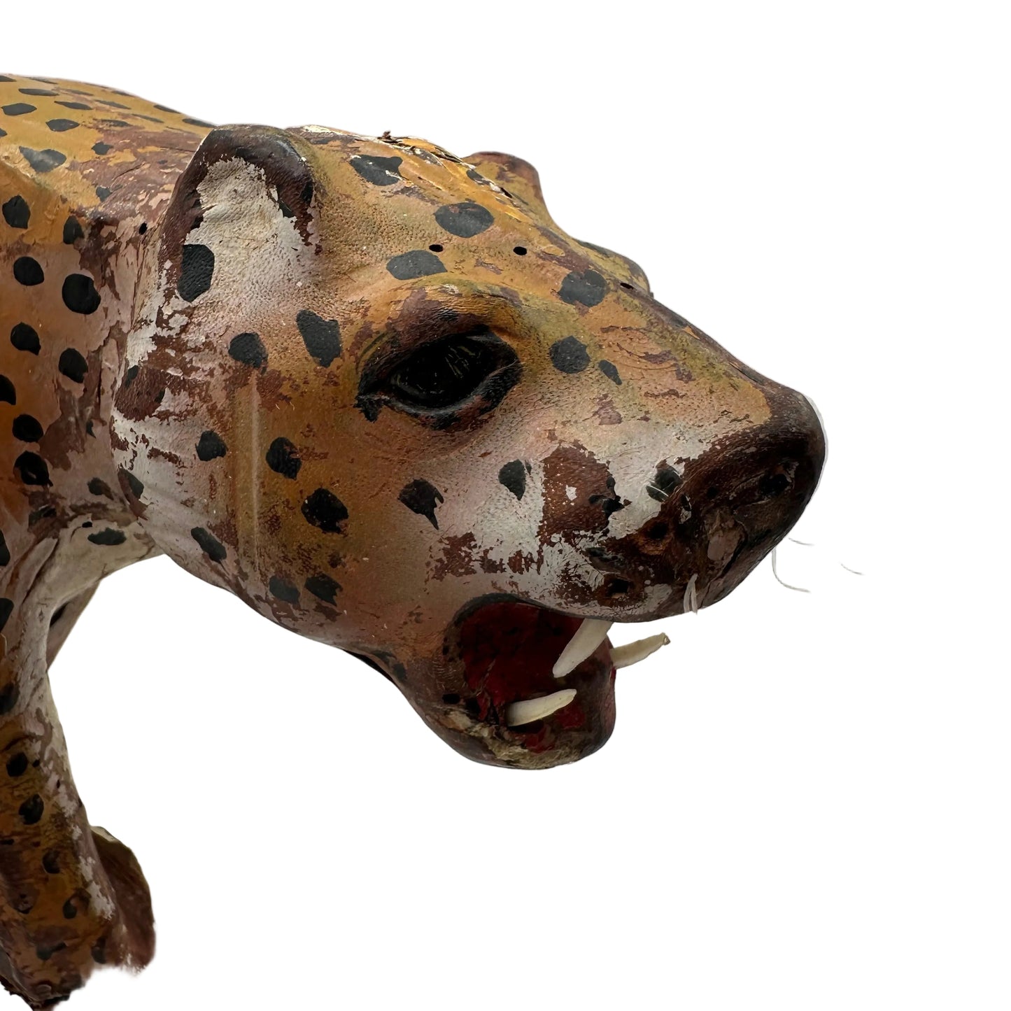 Close-up of leather leopard's painted face with glass eye, nylon whiskers and bared teeth