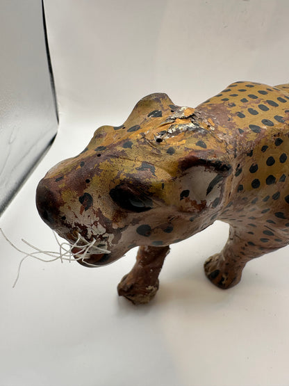 Front three-quarter view of leather leopard, head lowered, showing facial paint detail
