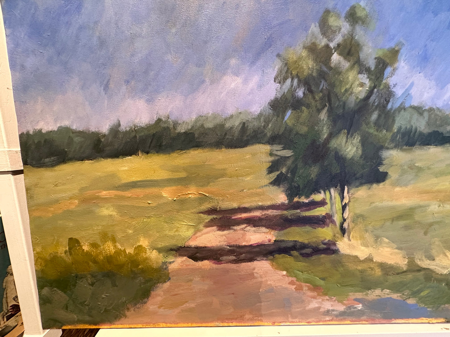 Vintage unframed country road landscape on canvas shown at an angle, revealing the canvas edge.