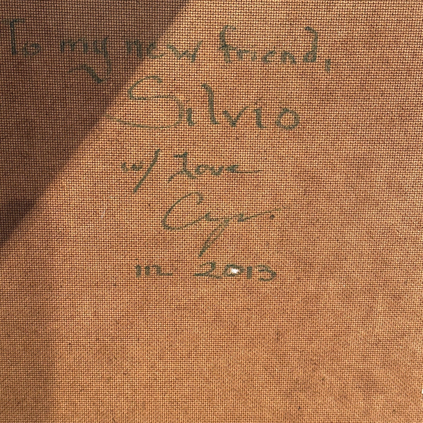 Close-up of green handwritten inscription on the reverse: "To my new friend, Silvio w/ Love," dated 2013.