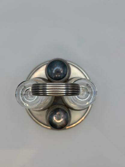 Top-down through the ring handle of the MCM cruet set showing shaker caps.
