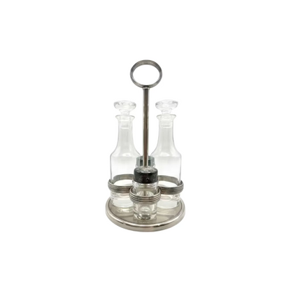 Vintage MCM silverplate cruet set: glass bottles and shakers in a footed stand with ring handle.