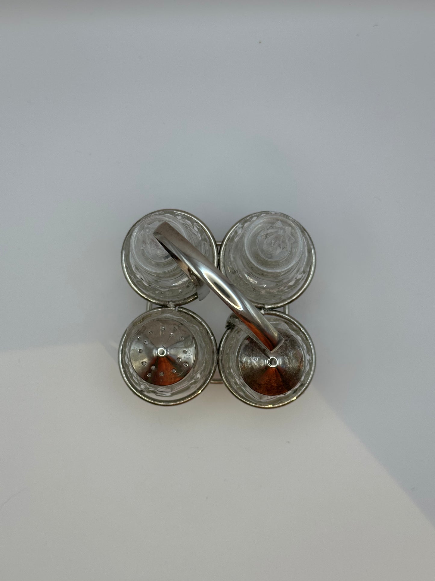 Cut-glass cruet set from above showing pierced shaker tops and glass stoppers.