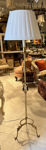 Gilt MCM Hollywood Regency floor lamp with white shade displayed in a furnished showroom