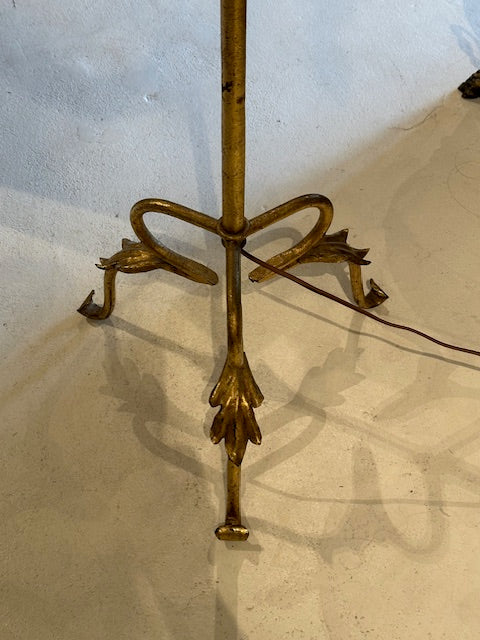 Top-down view of the gilt lamp's tripod base with scrolled bow detail and curled feet