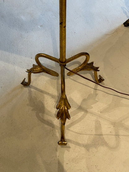 Top-down view of the gilt lamp's tripod base with scrolled bow detail and curled feet