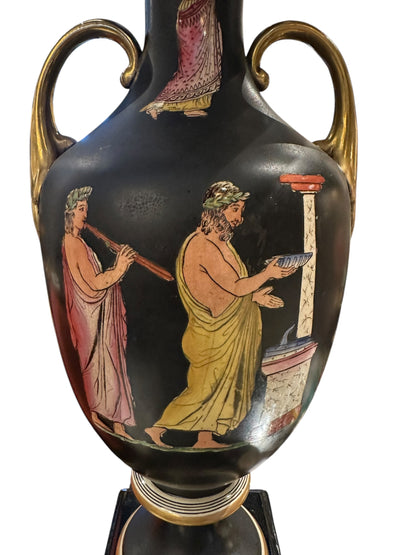 Close-up of the black lamp's painted classical scene: robed figures beside a column
