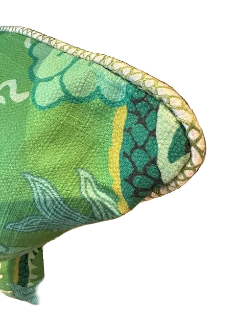 Close-up of the jade dragon pillow corner showing green dragon-scale print and corded trim