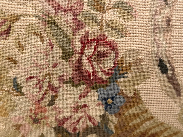 Detail of needlepoint pillow showing pink rose and blue forget-me-nots