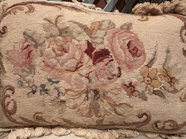 Close angled view of needlepoint pillow front, pink roses and foliage on tan ground