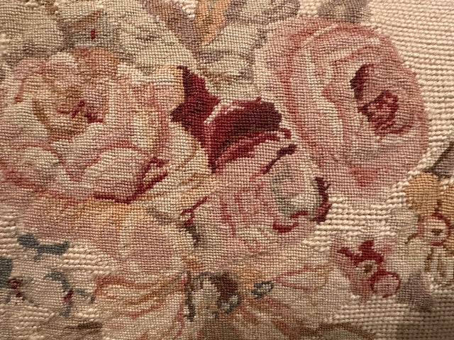 Detail of needlepoint pillow showing hand-stitched pink and burgundy roses