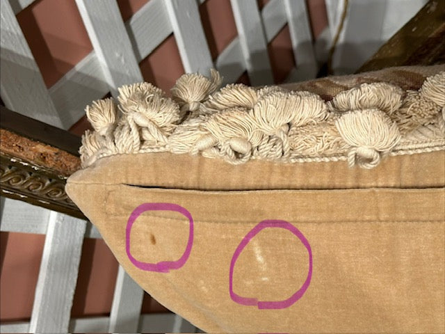 Back of needlepoint pillow, tan velvet with two circled wear flaws