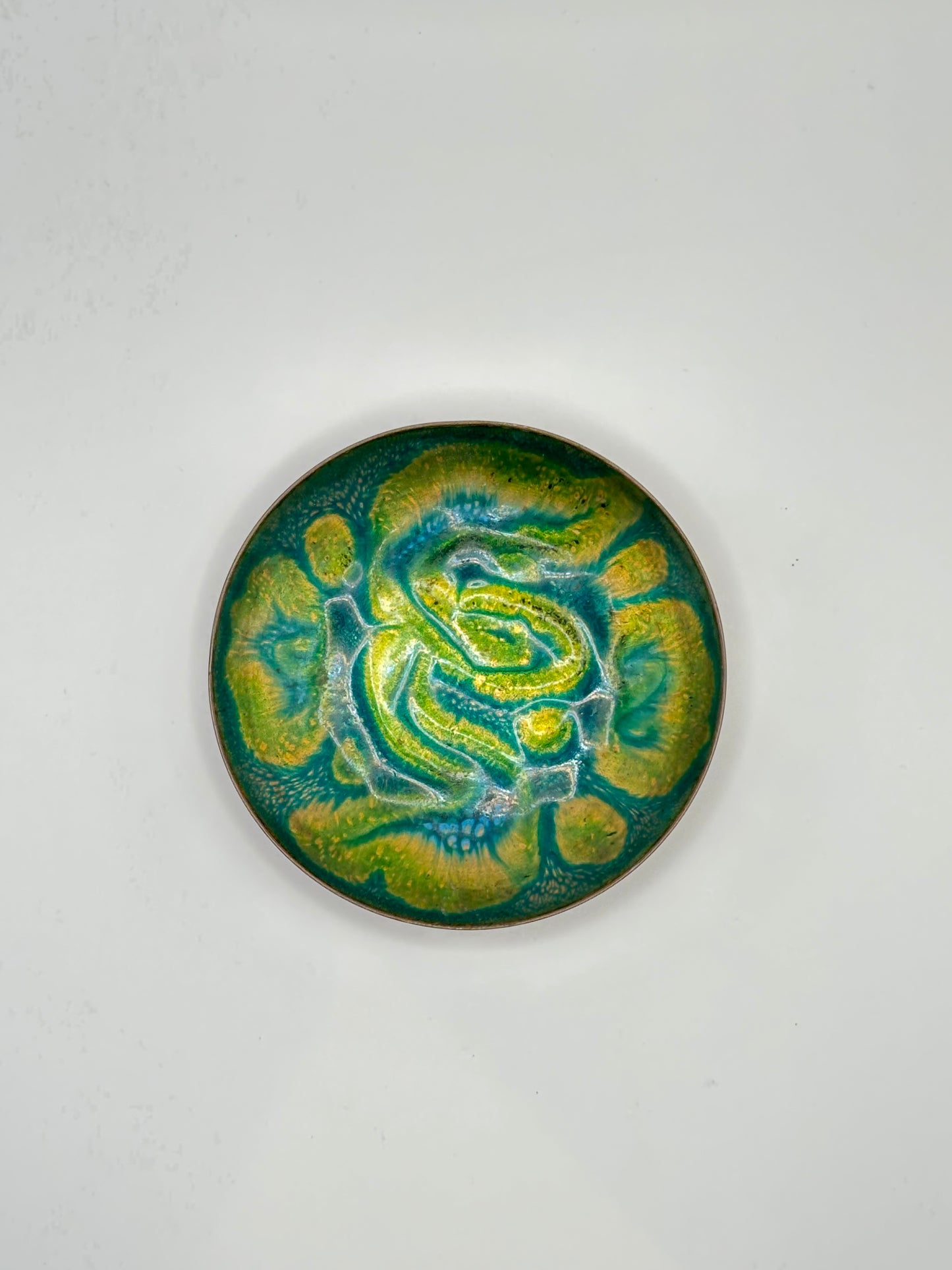 Doris Hall small enamel-on-copper dish, top view of green and yellow abstract swirl glaze