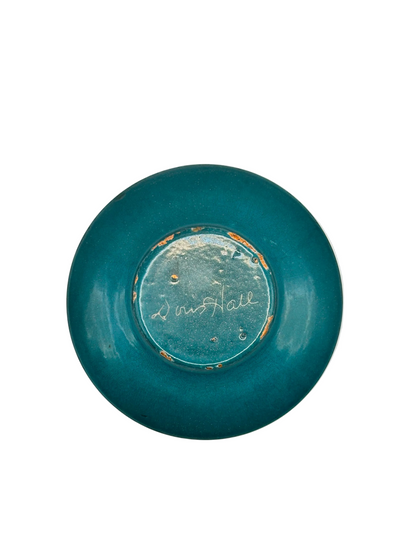 Underside of Doris Hall petite dish in dark-teal glaze, signed 'Doris Hall' in white script