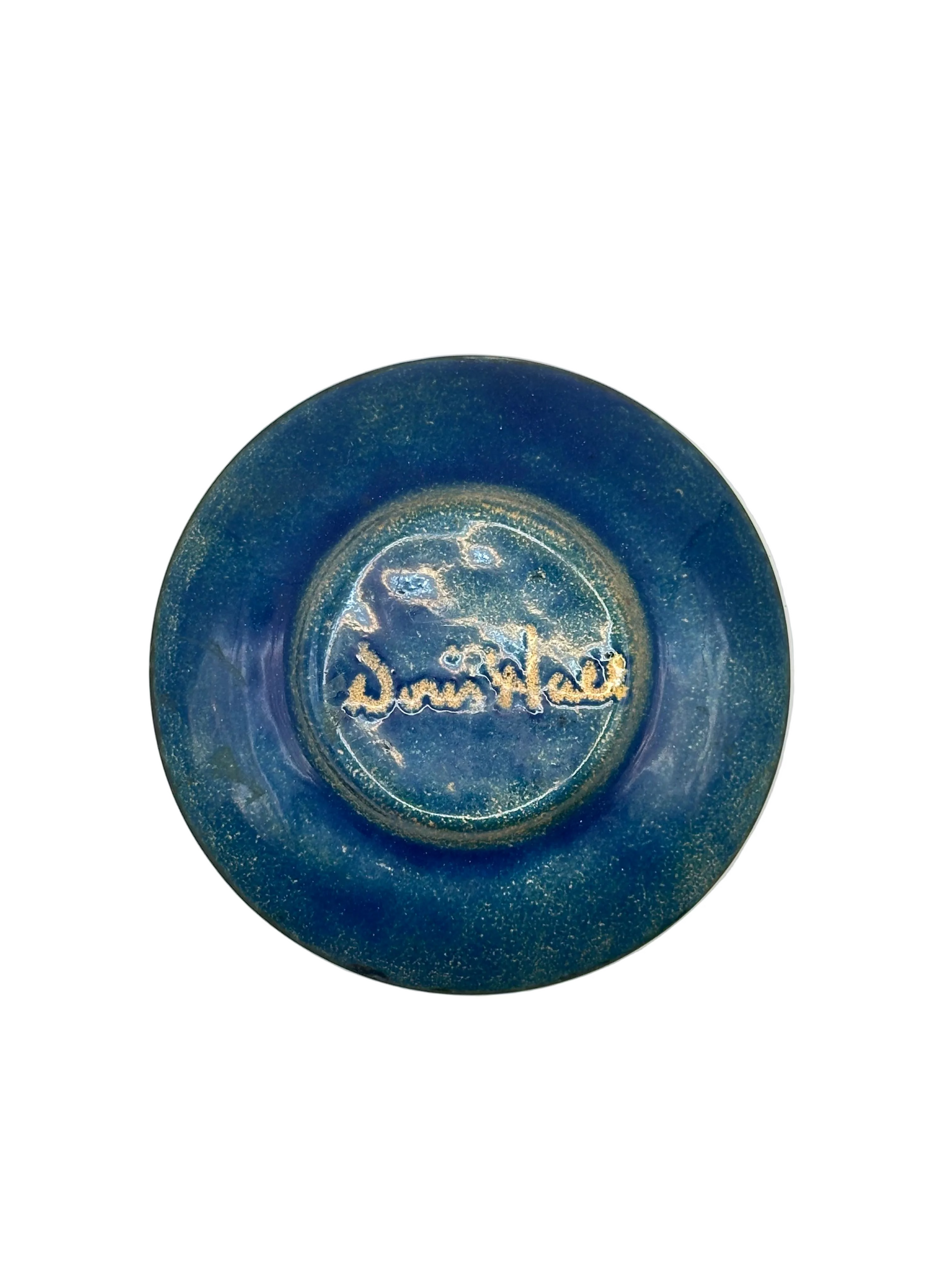 Underside of Doris Hall enamel dish in blue glaze, signed 'Doris Hall' in gold script
