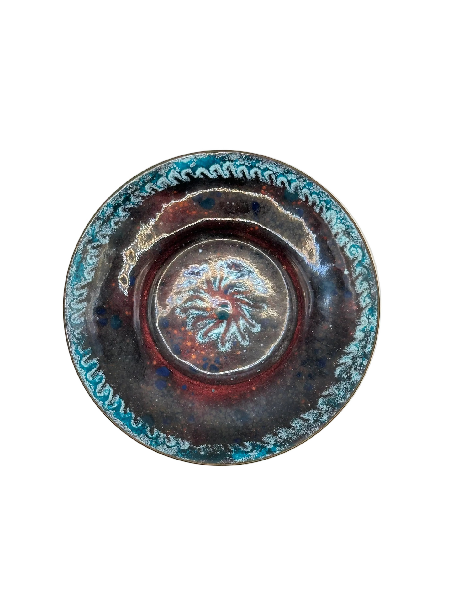 Doris Hall enamel dish, angled view of raised starburst medallion center in red and turquoise glaze