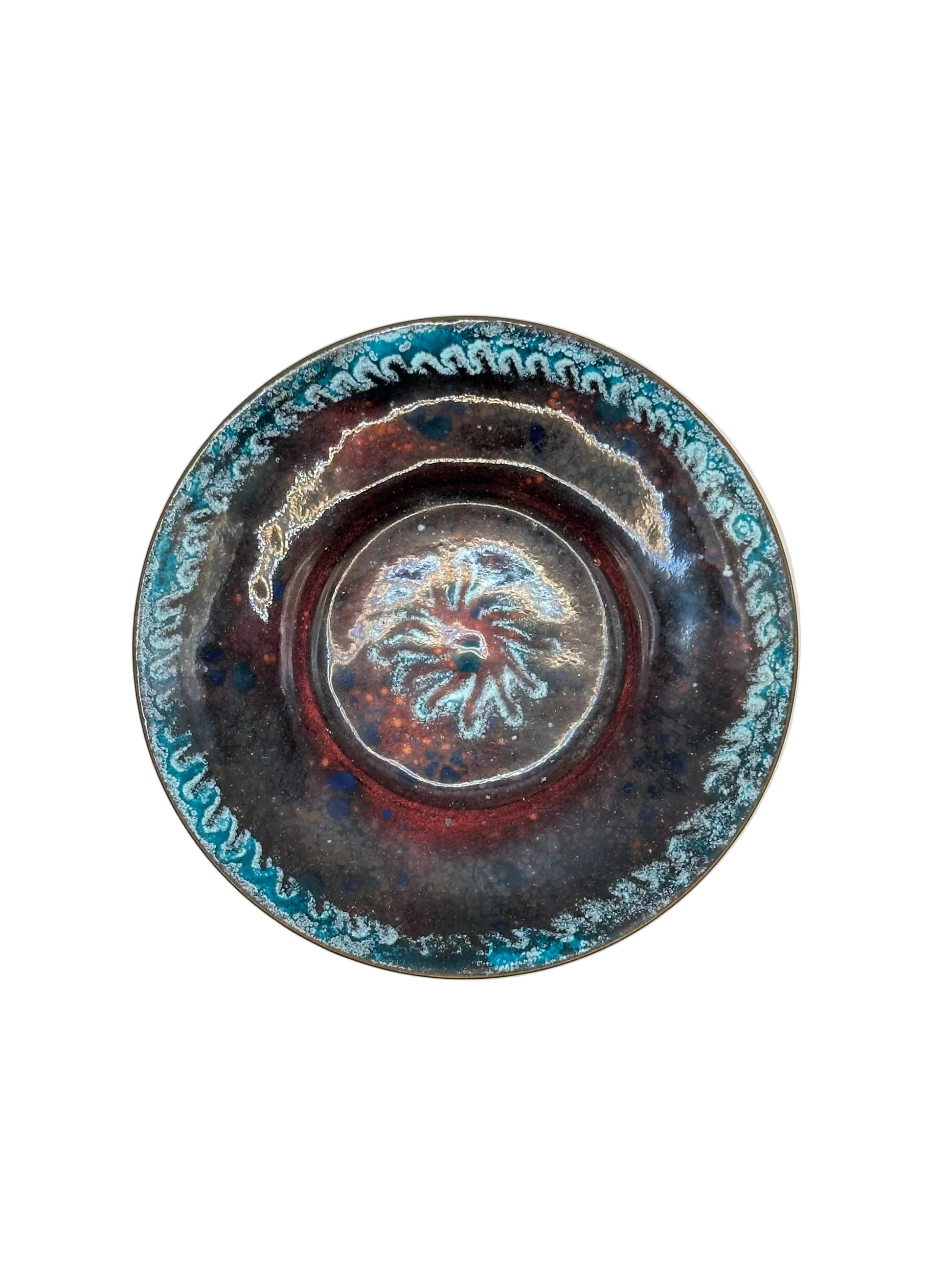 Doris Hall enamel dish, angled view of raised starburst medallion center in red and turquoise glaze