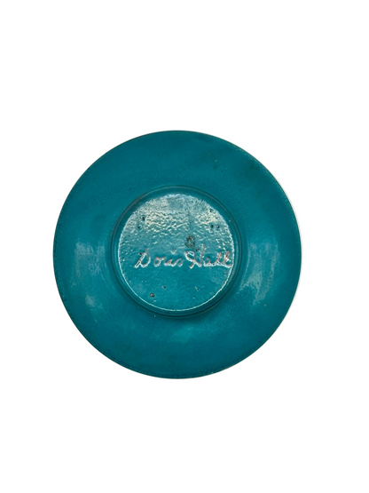 Underside of Doris Hall enamel dish in teal glaze, signed 'Doris Hall' in white script