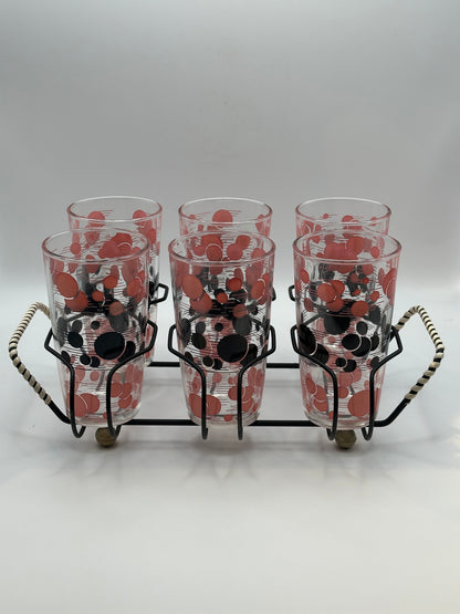 Six red and black polka-dot tumblers grouped together in the black wire carry caddy