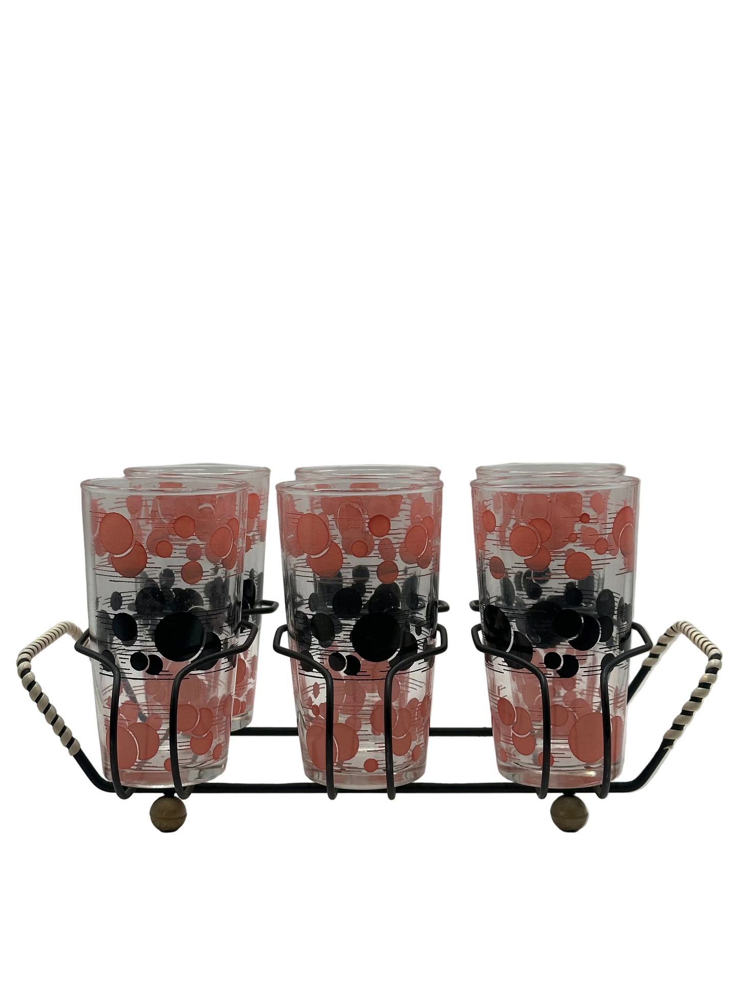 Set of red and black atomic polka-dot drinking glasses standing in a black wire carry caddy