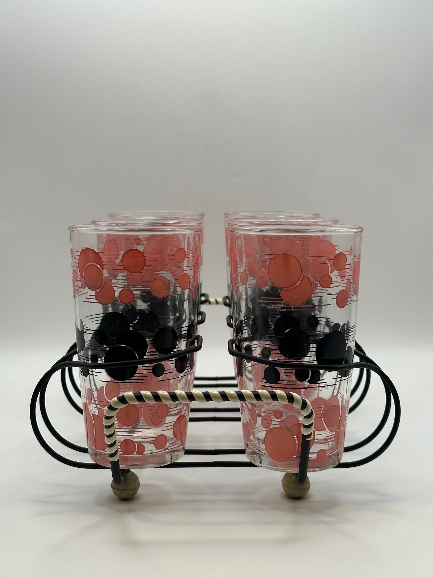 Close-up of two atomic polka-dot tumblers in the wire caddy with striped wrapped handle