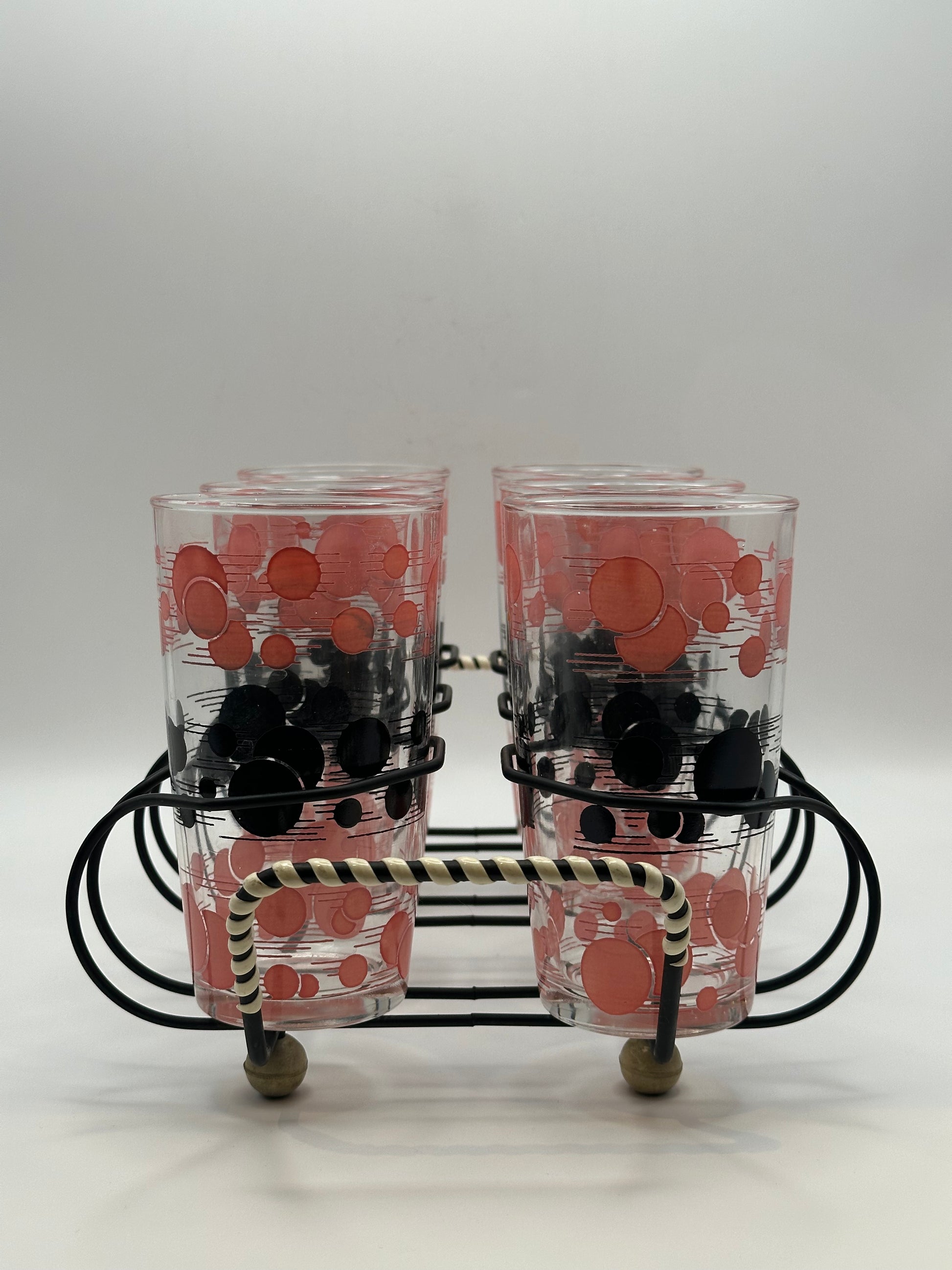 Close-up of two atomic polka-dot tumblers in the wire caddy with striped wrapped handle