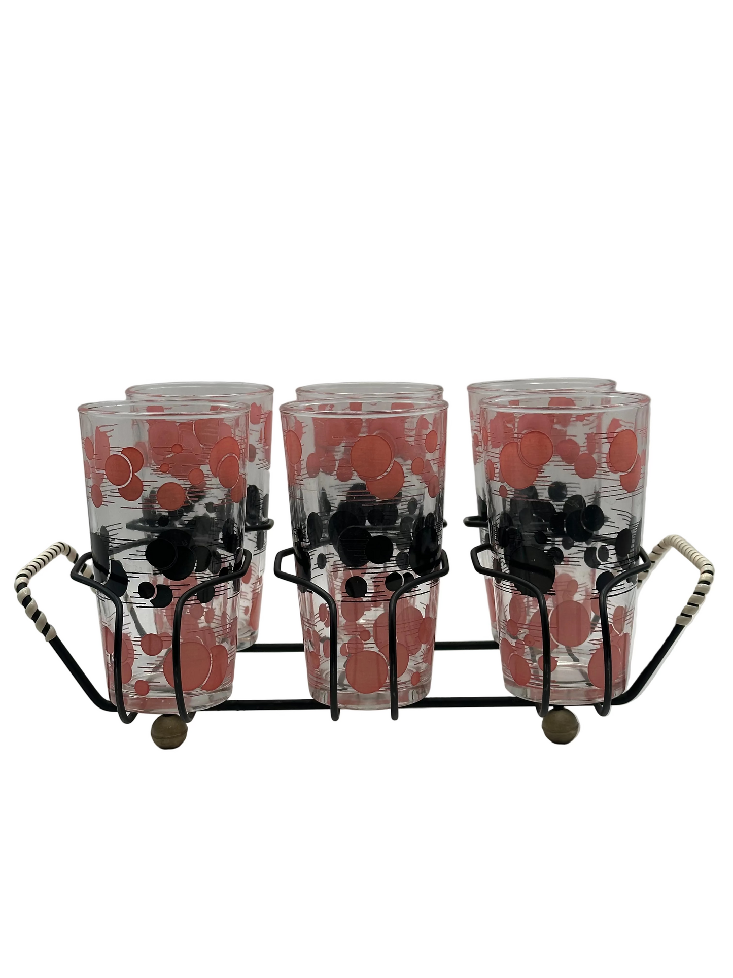 Angled view of the polka-dot tumblers seated in the black wire caddy with woven handles