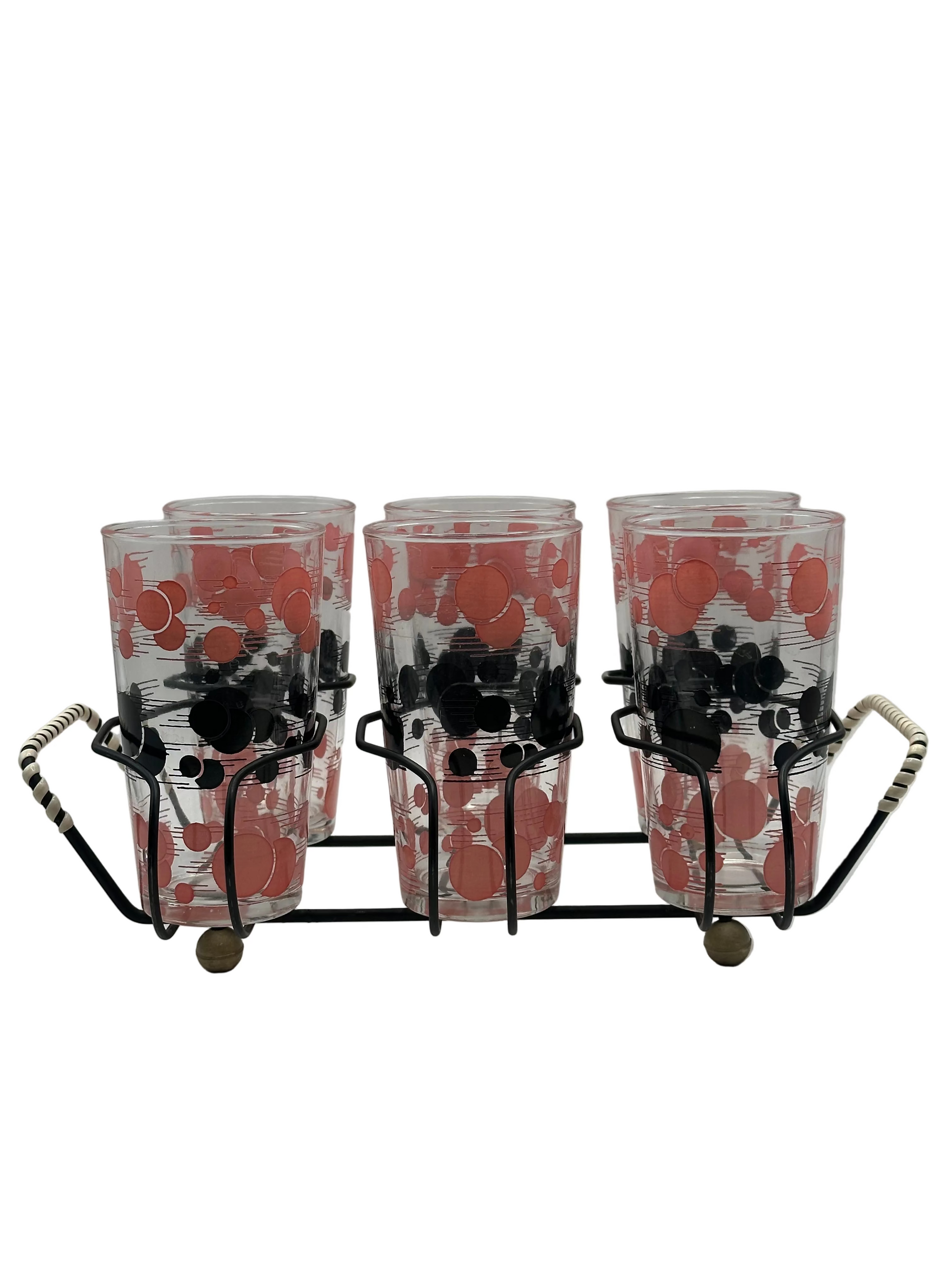 Angled view of the polka-dot tumblers seated in the black wire caddy with woven handles