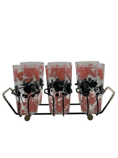 Angled view of the polka-dot tumblers seated in the black wire caddy with woven handles