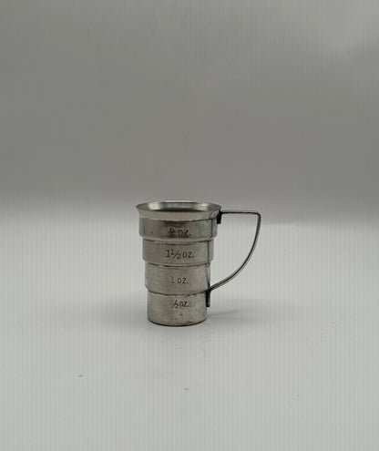 Vintage Art Deco silver-plate jigger showing engraved ounce measurements, wire handle to the right