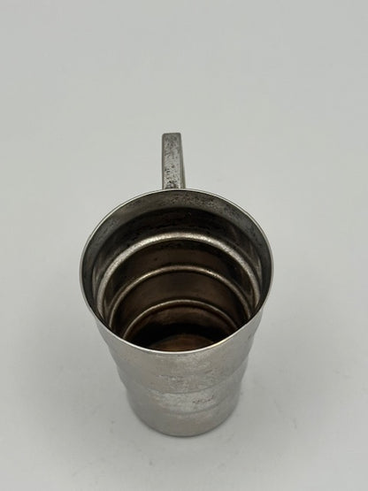 Vintage Art Deco silver-plate jigger viewed from above into the cup, showing tiered interior and handle