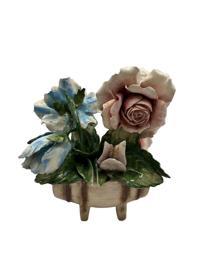 Front view of the porcelain arrangement with a full pink rose, blue flower and white lily