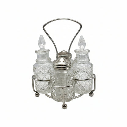 Vintage 4-piece cut-glass cruet set with pointed stoppers and a shaker in a footed silverplate stand.