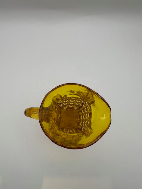 Top-down view into amber pressed-glass cruet showing square diamond-patterned interior