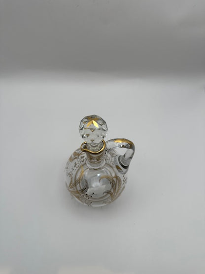 Angled view of the gilt-decorated glass cruet with faceted ball stopper and applied loop handle