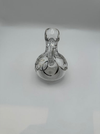 Top-down view of clear glass cruet showing spout, handle and silver overlay detailing