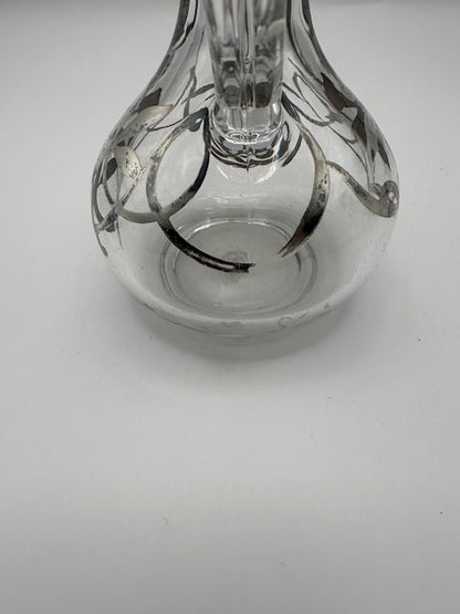 Close-up of clear glass cruet base showing bulbous body and silver floral overlay