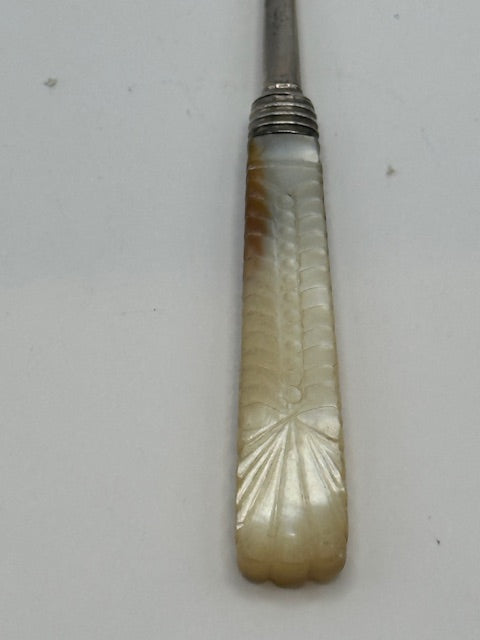 Close-up of the carved mother-of-pearl handle with fan motif