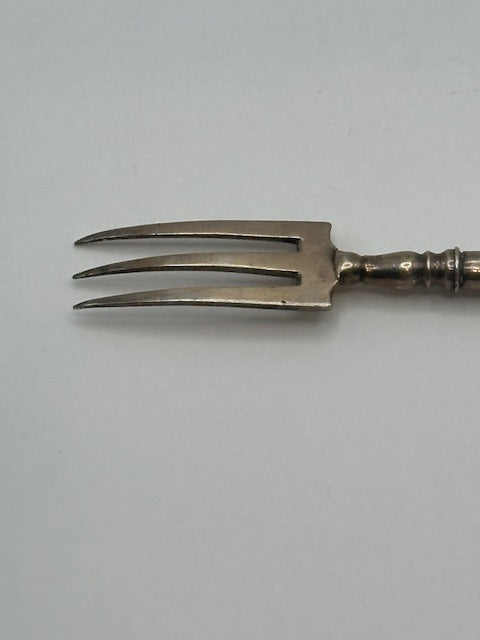 Close-up of the three curved sterling tines and silver ferrule
