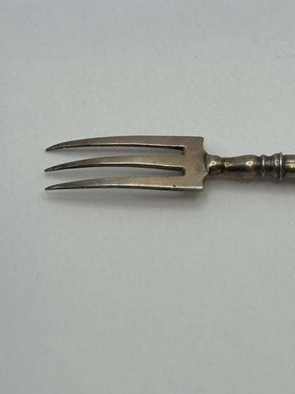 Close-up of the three curved sterling tines and silver ferrule