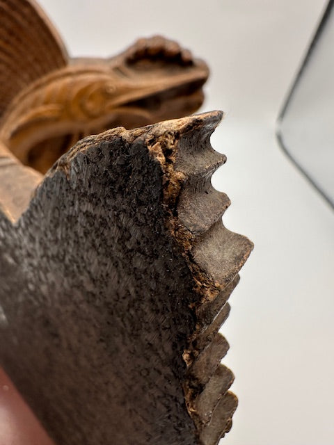 Close-up of a wood sailfish bookend's textured fin with the second bookend behind