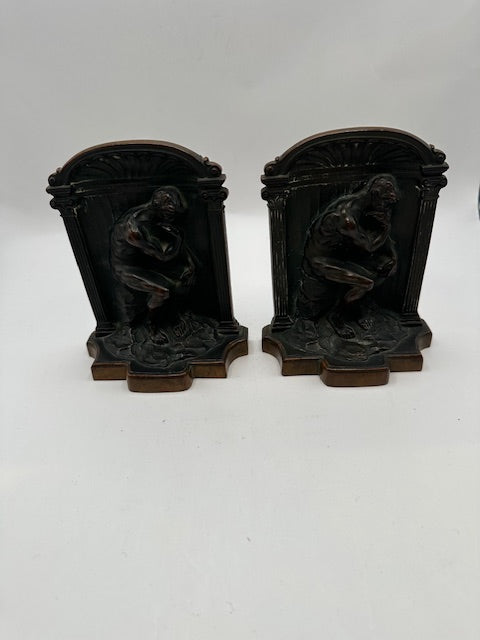 Bronze Thinker bookends standing together against a black background, front view