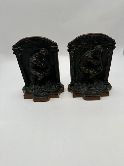 Bronze Thinker bookends standing together against a black background, front view